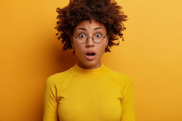 Photo gratuite une femme afro-américaine choquée et inquiète ouvre la bouche, témoin d'une scène choquante