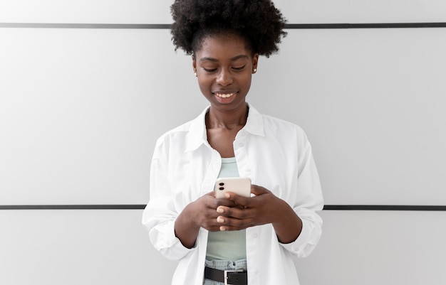 Photo gratuite femme afro-américaine envoyant un sms à quelqu'un sur son smartphone