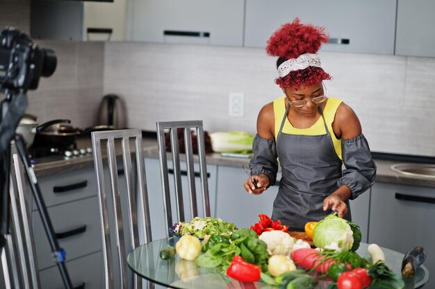 Femme afro-américaine filmant son blog diffusé sur des aliments sains dans la cuisine à domicile