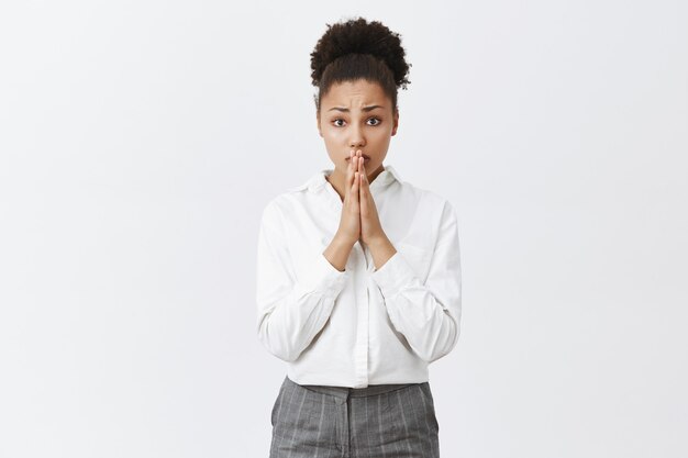 Une femme afro-américaine inquiète espère demander faveur, une femme d'affaires a besoin d'aide