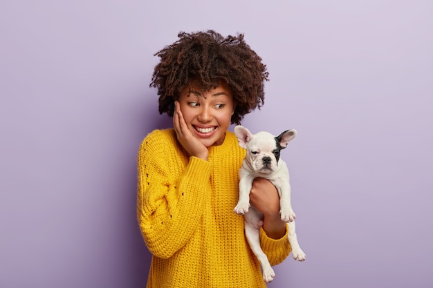 Femme afro-américaine ludique heureuse d'acheter un chiot de race