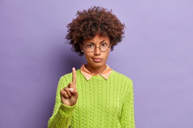 Femme afro-américaine mécontente sérieuse lève le doigt et vous avertit