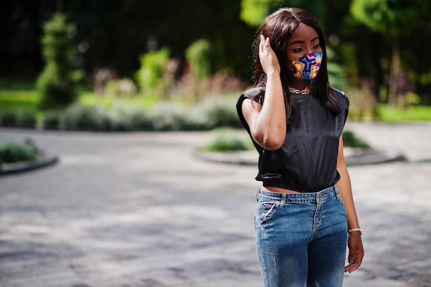 Photo gratuite une femme afro-américaine à la mode porte un masque facial fait à la main posant en plein air nouvelle vie normale