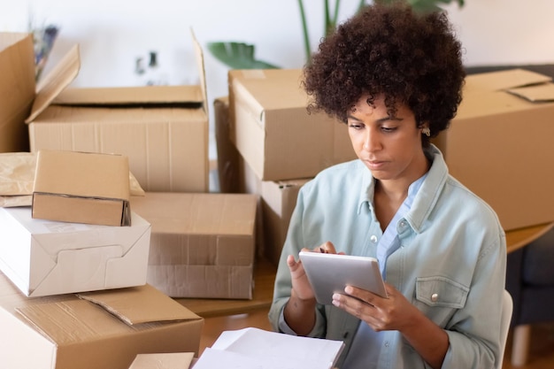 Photo gratuite femme afro-américaine occupée à l'aide de tablette