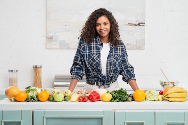 Photo gratuite femme afro-américaine posant à côté de légumes