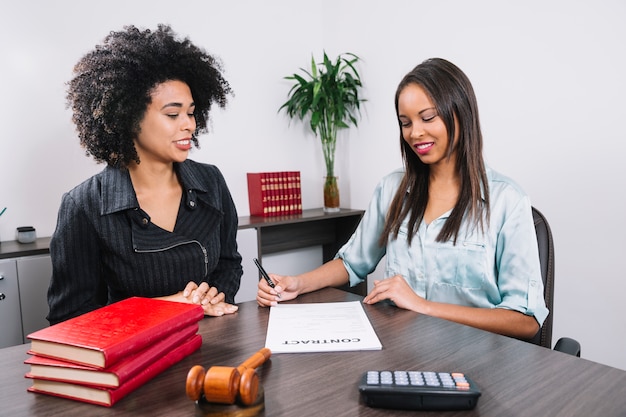 Femme afro-américaine, près, dame, écriture, dans, document, à, table