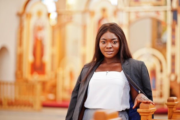 Femme afro-américaine priant dans l'église Les croyants méditent dans la cathédrale et le temps spirituel de la prière