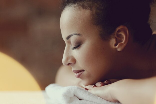 Femme afro-américaine recevant un massage relaxant au spa