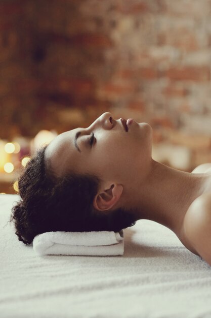 Femme afro-américaine recevant un massage relaxant au spa