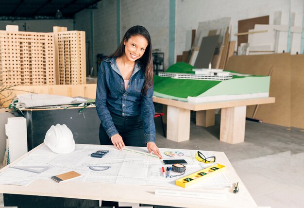 Femme afro-américaine avec une règle sur la table près d&#39;un casque et des équipements de sécurité