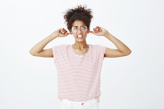 Photo gratuite femme agacée avec une coiffure afro qui pose en studio