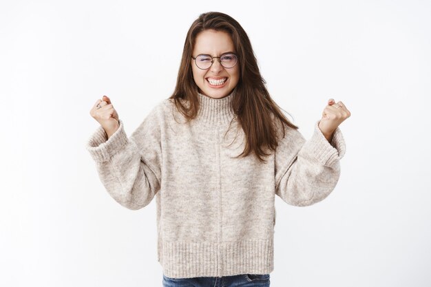 femme agacée et énervée comme s'enflammer de haine et de colère se sentant sous pression et tendue par l'irritation serrant les dents et les poings levés dans des émotions haineuses mécontentes grimaçant dérangé.