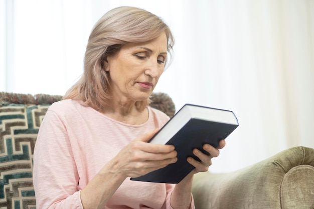 Femme d'âge moyen Hoding Bible en mains et en le regardant