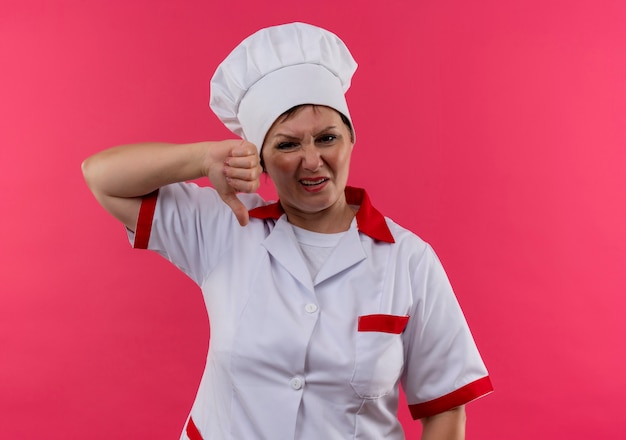 Femme d'âge moyen mécontente cuisinière en uniforme de chef son pouce vers le bas