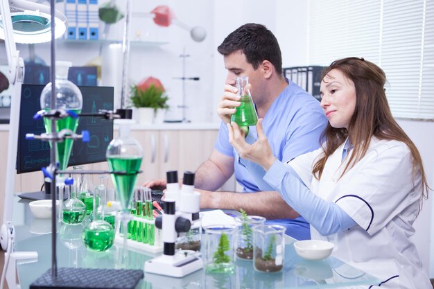 Femme d'âge moyen avec son assistante travaillant dans un laboratoire de recherche en microbiologie. Tubes à essai.