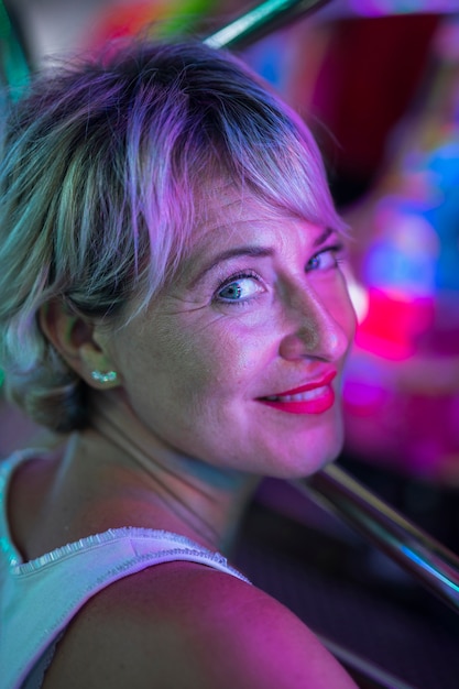 Femme d'âge moyen souriante se demandant des lampes rougeoyantes