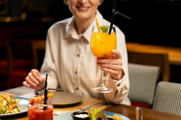 Photo gratuite femme âgée buvant dans un restaurant