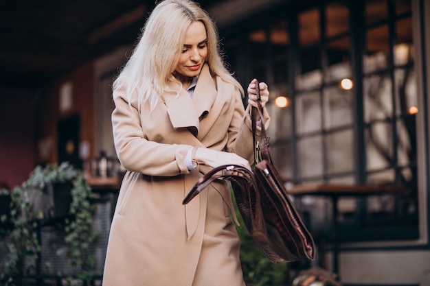 Femme âgée dans un manteau à l'extérieur du café