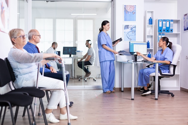 Photo gratuite femme âgée avec déambulateur dans la salle d'attente de l'hôpital pour un traitement de réadaptation