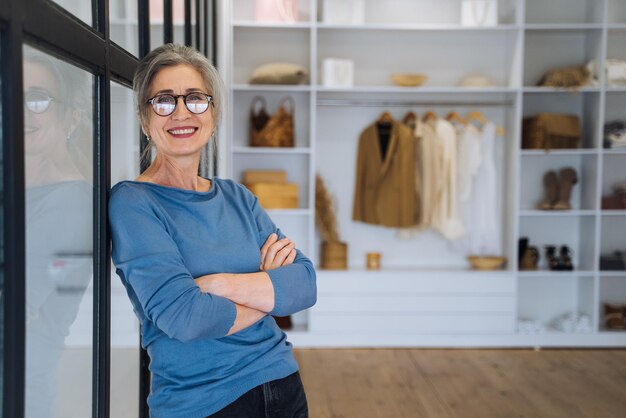 Femme âgée gardant les bras croisés sur sa poitrine regardant la caméra avec un sourire confiant