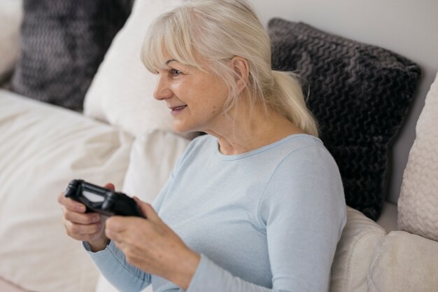 Femme âgée jouant à des jeux vidéo
