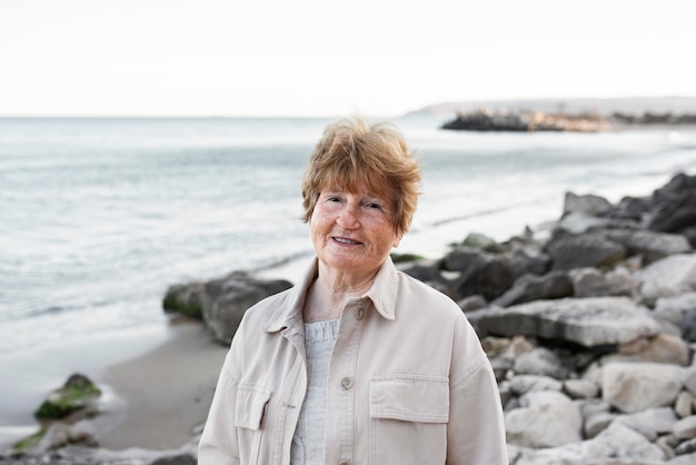 Femme âgée marchant au bord de la mer