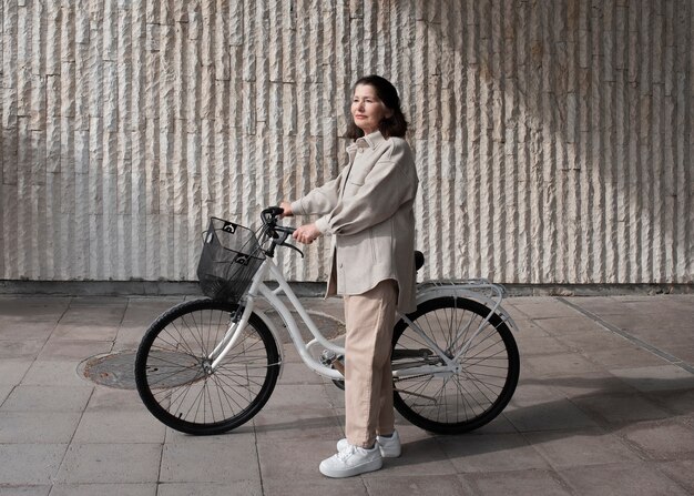 Femme âgée marchant avec son vélo