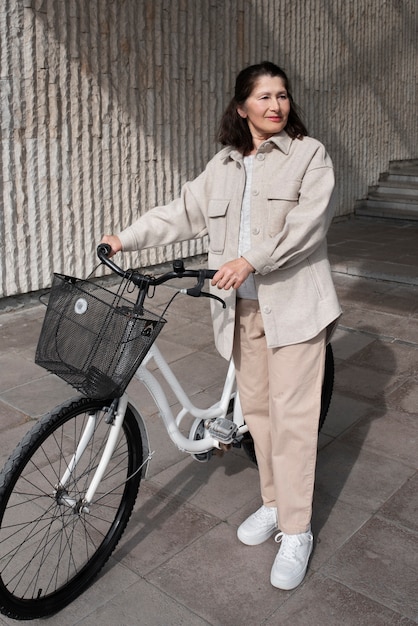 Femme âgée marchant avec son vélo