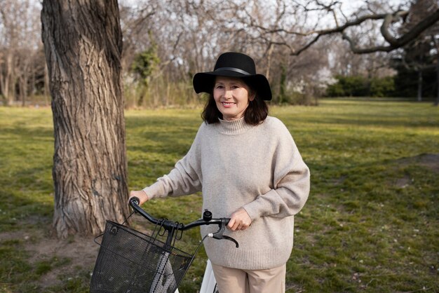 Femme âgée marchant avec son vélo