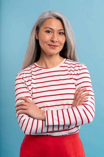 Femme âgée posant sur un fond bleu