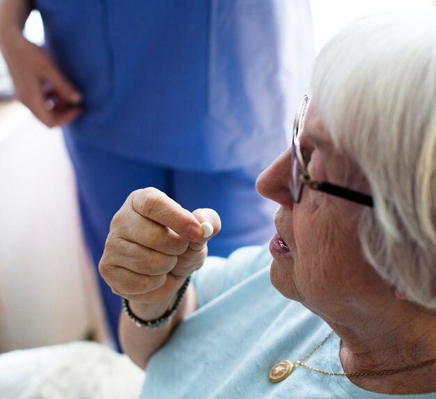 Femme âgée prenant un médicament