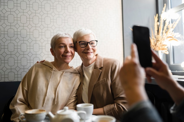 Femme âgée prenant une photo de ses amis lors d'un rassemblement