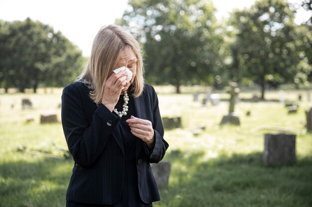 Femme âgée visitant la tombe d'un être cher