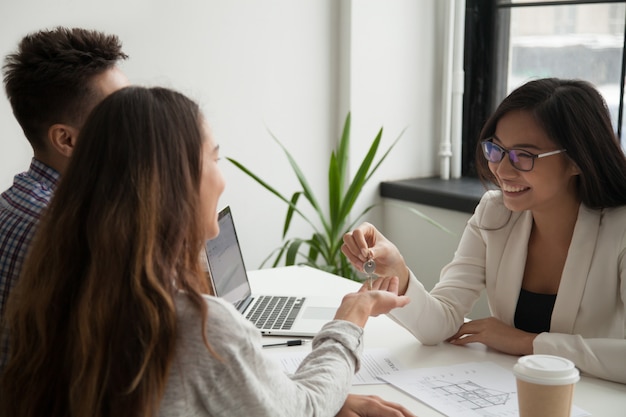 Femme agent immobilier remettant les clés d&#39;un couple excité