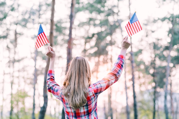 Femme agitant de petits drapeaux américains à l&#39;extérieur