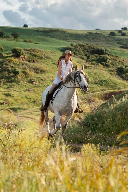 Femme agricultrice équitation en plein air dans la nature