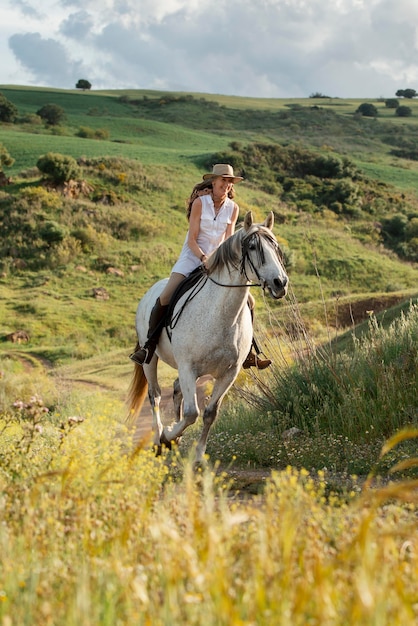 Femme agricultrice équitation en plein air dans la nature