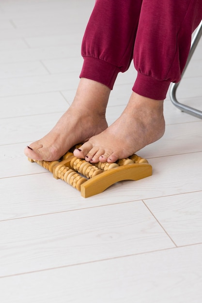 Femme à l'aide d'un appareil de massage des pieds