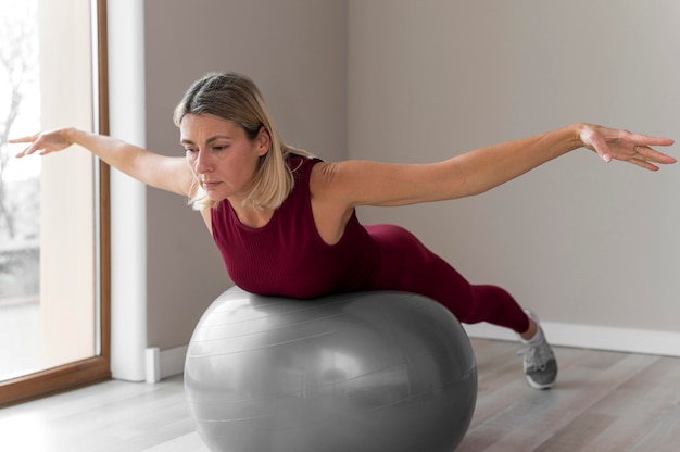 Femme à l'aide d'un ballon de fitness pour son entraînement