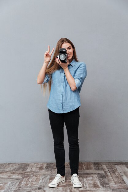 Femme à l'aide d'une caméra vidéo rétro