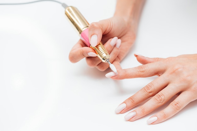 Photo gratuite femme à l'aide d'une lime à ongles numérique vue haute