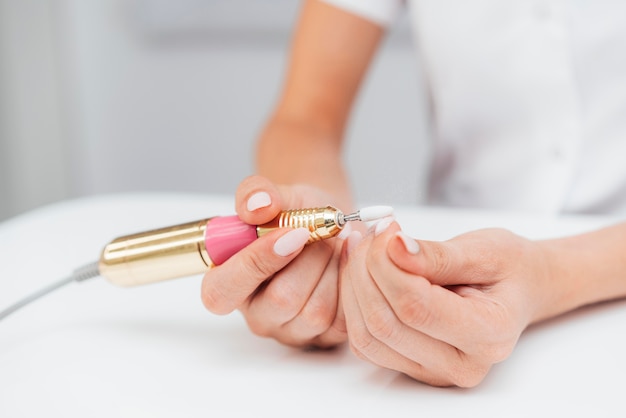 Photo gratuite femme à l'aide d'une lime à ongles numérique