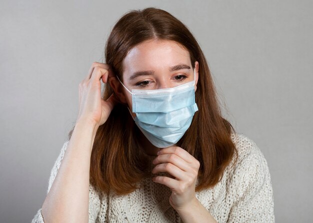 Femme à l'aide d'un masque médical pour la protection