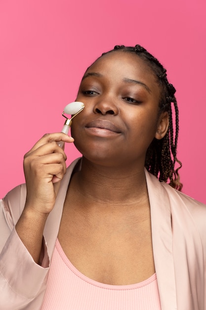 Photo gratuite femme à l'aide d'un rouleau de visage