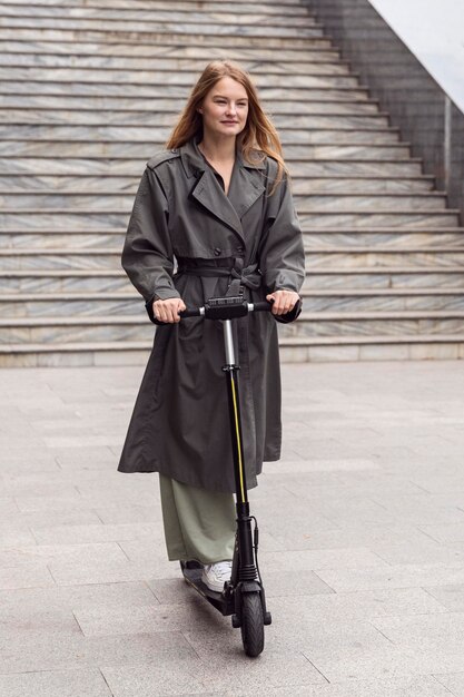 Femme à l'aide d'un scooter électrique à l'extérieur