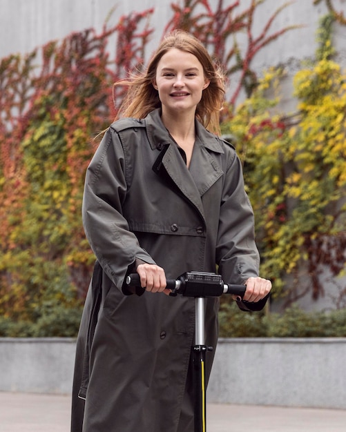 Femme à l'aide d'un scooter électrique à l'extérieur