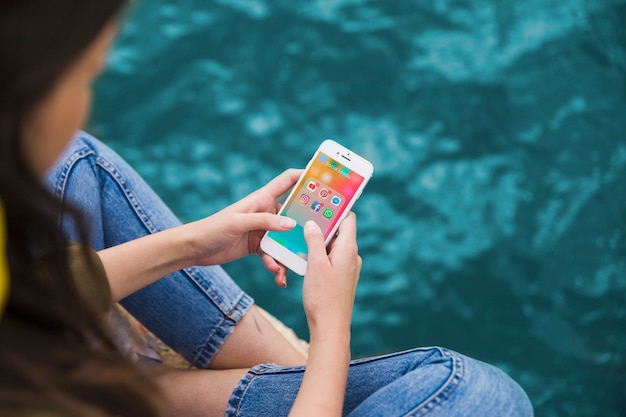 Femme à l&#39;aide de téléphone portable avec des notifications de médias sociaux à l&#39;écran