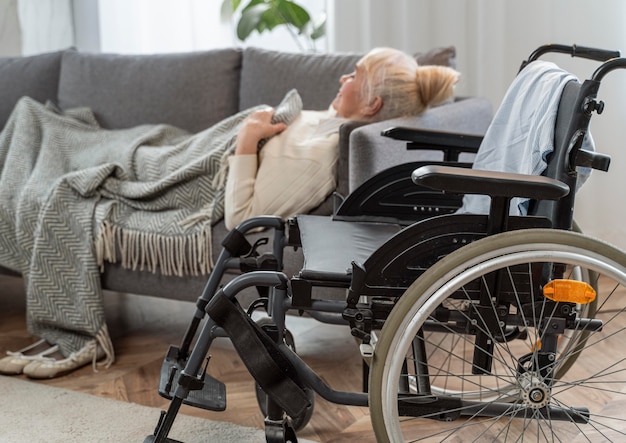 Femme aînée, coucher lit, côté, a, fauteuil roulant