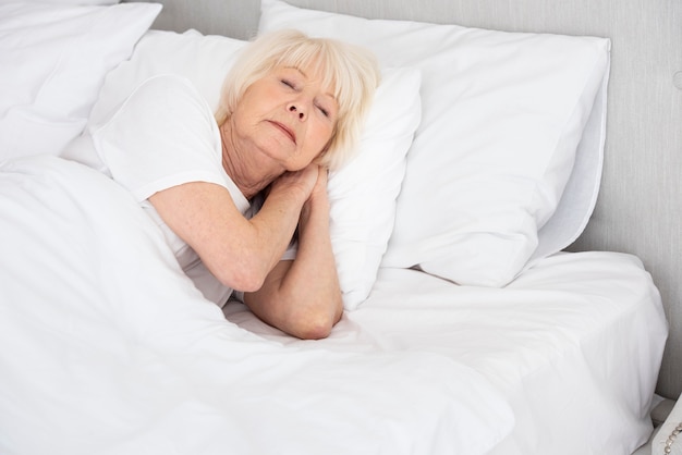 Femme aînée dormant dans son lit