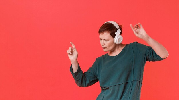 Femme aînée écoutant de la musique et dansant